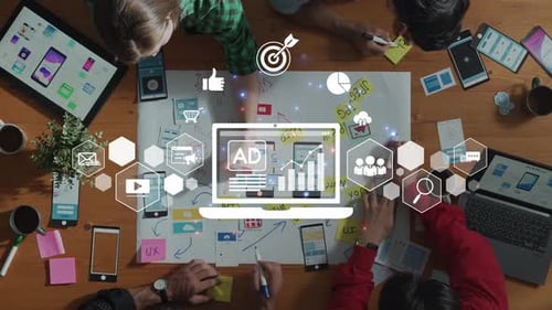 Espacio de trabajo colaborativo con estrategia de marketing digital e imágenes específicas sobre una mesa rodeada de bolígrafo