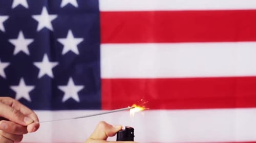 Sparkler Ignited in Front of American Flag Background