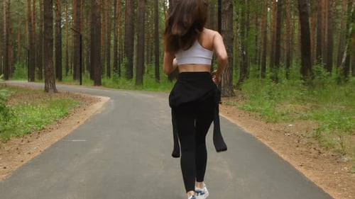 Athletic Woman Black Leggings White Tank Top Runs Confidently Along Pine Forest Asphalt Path