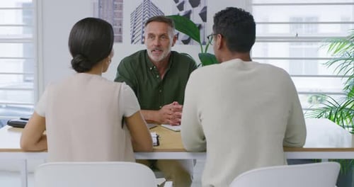 Mature Adult Talking to Young Adults at Office