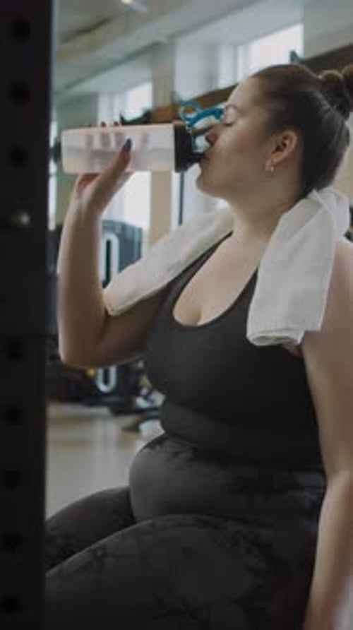 Curvy Young Woman Resting after Working Out at Gym
