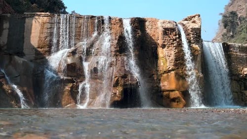 Waterfall cascade through the rocky trails in forest wide shot
