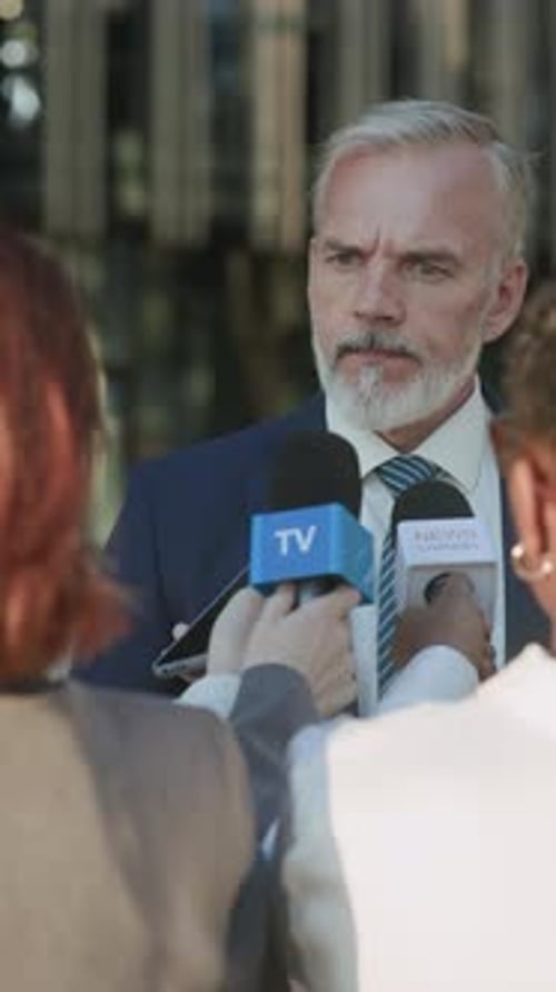 Man Answers Press Conference Questions in Urban Setting