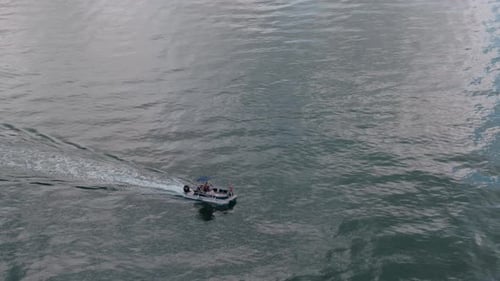 Vidéo aérienne d'un bateau blanc naviguant vers la mer bleue et se déplaçant à grande vitesse