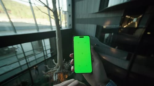 Unrecognizable Caucasian Man Hands Holding Smartphone with Green Screen and Scrolling Through Social