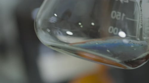 Close Up of Flask with Moving Liquid in Scientific Laboratory.