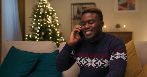 Young Adult Chatting on Phone at Christmas