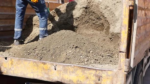 Using a Green Shovel a Person is Digging in the Soil