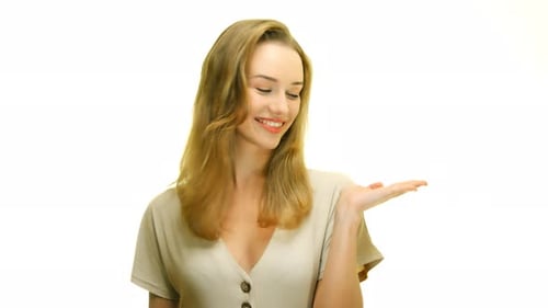 A close-up of a woman holding her hand up, palm face up, on a seamless white studio background