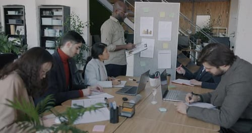 Business Team Attends Presentation in Modern Office