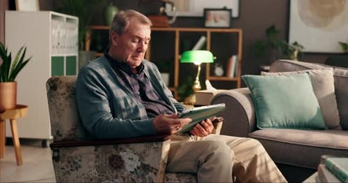Senior Man Using Tablet Device at Home