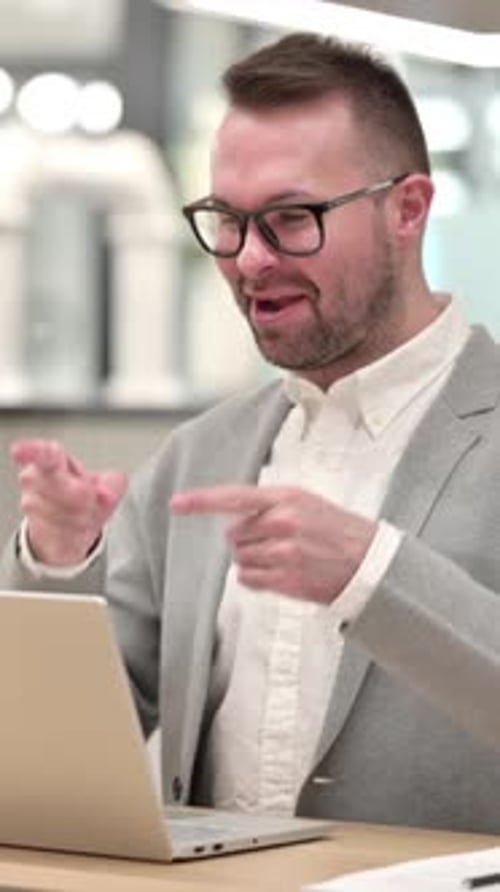 Man in Blazer Video Calling on Laptop Indoors
