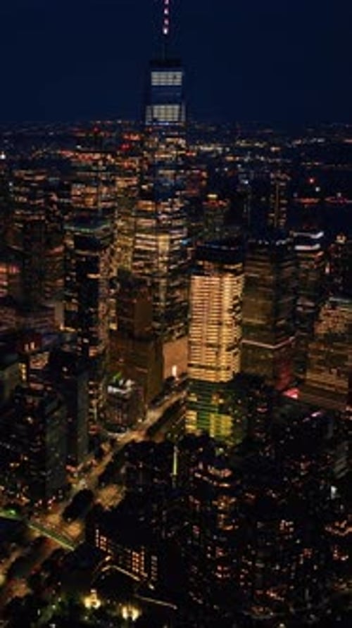 Impressive night scenery of New York. Drone descending above the vibrant city. Vertical video
