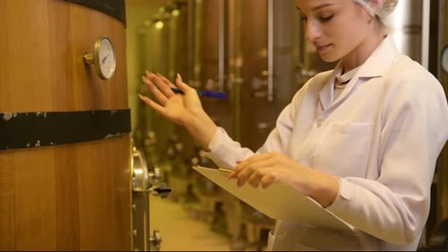 Vigneron professionnel contrôlant le processus de fabrication et la qualité du vin dans une usine vinicole
