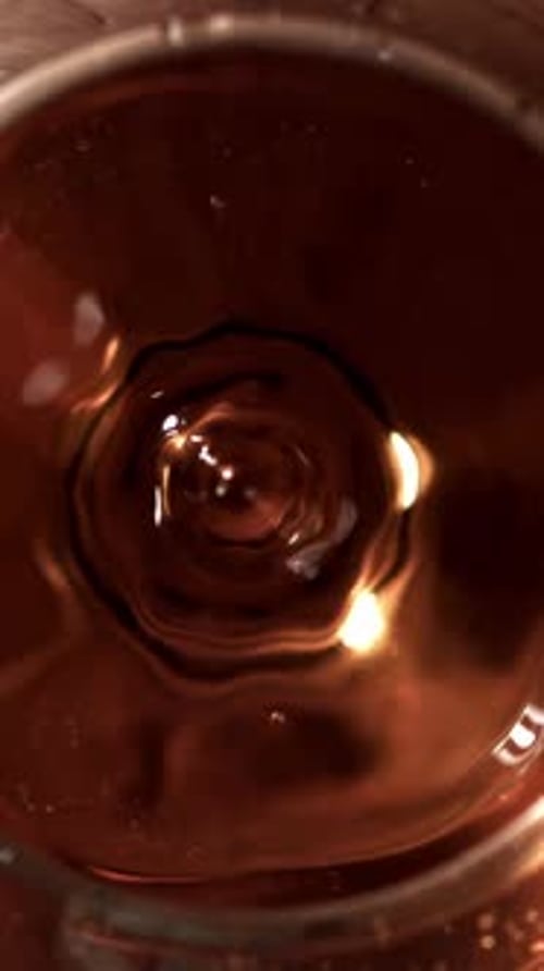 A Drop Falls Into a Glass of Cognac Filmed on a Highspeed Camera at 1000 Fps