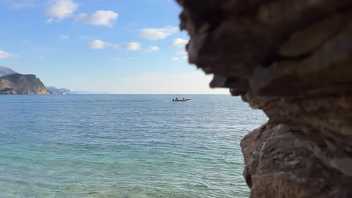 The Boat Floats on a Calm Transparent Sea View From the Shore