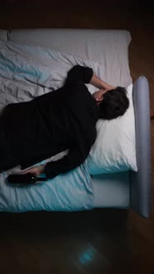Man Sleeping in Bed with Wine Bottle