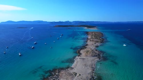 Formentera island coastline, boats on clear turquoise water. Marvelous aerial view drone