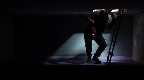 Man Climbs Down Ladder Into Dark Basement With Lantern