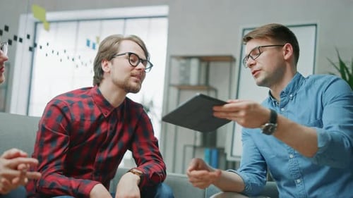 Coworkers Reviewing a Tablet Together in an Office