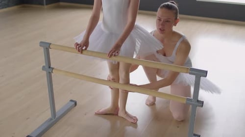 Teacher Helping Small Ballerina to Stand in First Position