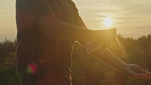 Sunset Safety Man Sprays Mosquito Repellent on Mountain