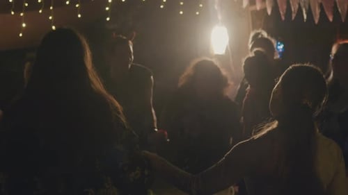 Unrecognizable Crowd Dancing and Leading Round Dance at Night Party
