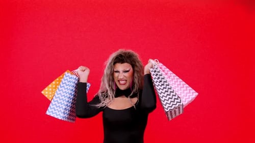 Glamorous Person Flaunts Shopping Bags in a Red Studio