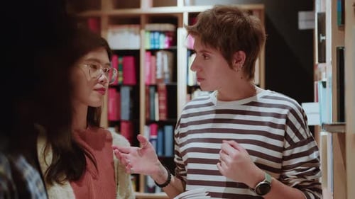 Une jeune étudiante explique son projet à ses camarades de groupe à la bibliothèque