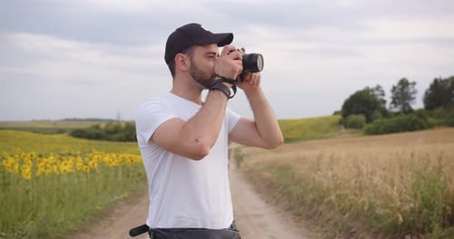 Man Taking Pictures in Rural Sunflower Field