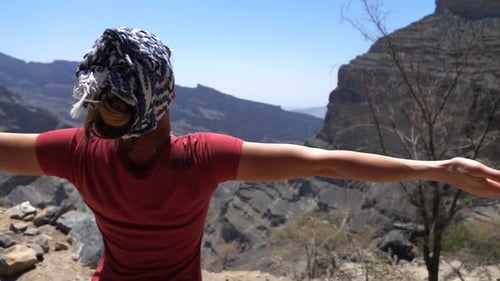 Frau mit offenen Armen genießt sonnigen Sommertag in der Nähe der Grand Canyon-Berge