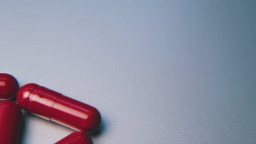 Red Capsules on Light Blue Background, Close Up