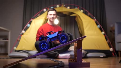 Man plays with toy car indoors