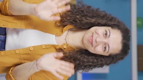 Smiling Woman Waving Hello at the Camera