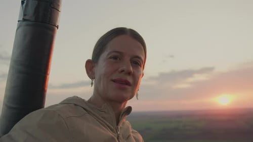 Femme souriant avec confiance dans la chaude lueur du coucher du soleil à l'extérieur