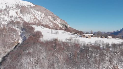 Aerial view of snowcapped mountains scenic valley idyllic mountain village and alpine woodland in wi