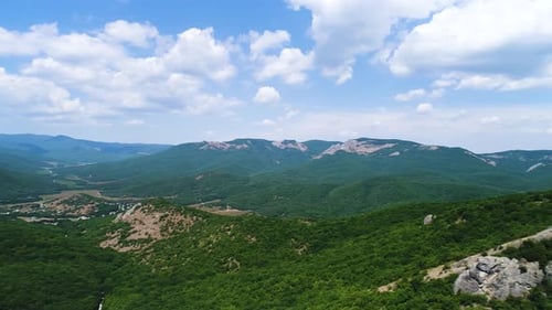 Majestic Green Mountains and White Clouds Panning Across the Landscape