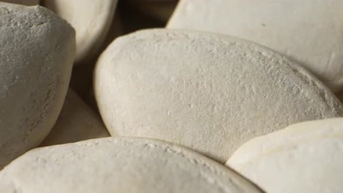 Pumpkin seeds, small and oval-shaped.