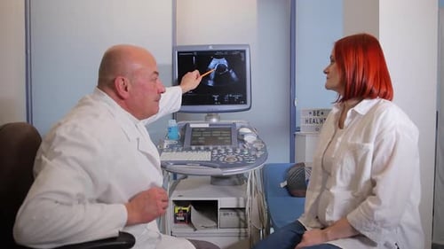 гинеколог беседует с беременной пациенткой в кабинете