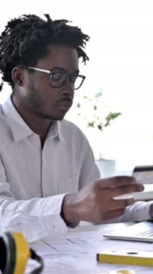 Young Man Uses Credit Card on Laptop at Desk