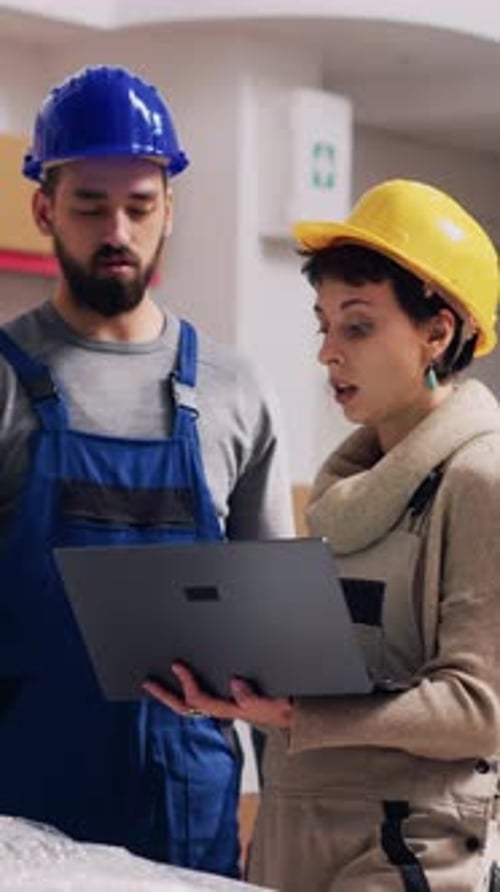 Construction Employees Discussing Plans on Laptop