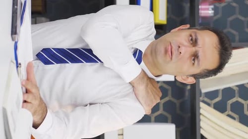 Man Working At Desk Massaging Shoulder In Pain