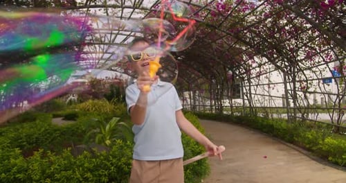 Joy Kid Play with Soap Bubbles in Park Summer Day Happy Child Closeup Blowing Soap Bubbles Against