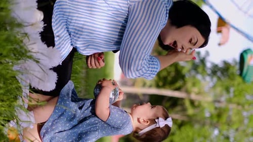 Mother and child together in the park outdoors, lying in the grass. Motherhood happiness concept. Da