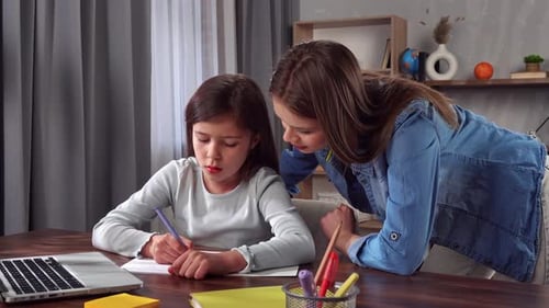 Young Child Girl Studying at Home Small Girl Sits at Desk and Attends School Class Online on Laptop