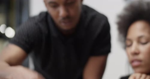 Colleagues Collaborating on Tablet Device in Office