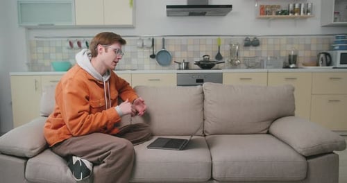 Young Adult Video Conferencing on Laptop at Home