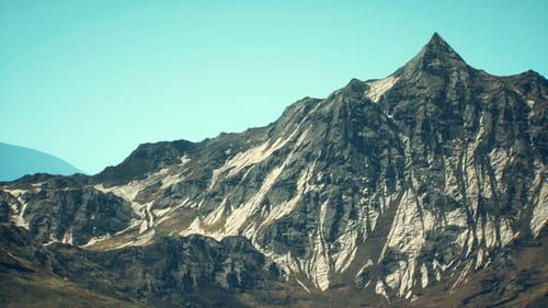 Majestic Mountain Peak Rising Against a Clear Blue Sky in Daytime Landscape