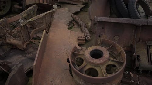 Detailed Inspection of Deteriorated Mechanical Parts Amidst Scattered Debris and Faded Brown Tones