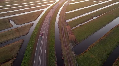 Cars Driving On Rural Road At Dusk Through Beyersche Vliet Canal And Dutch Polders In Gouderak, Neth
